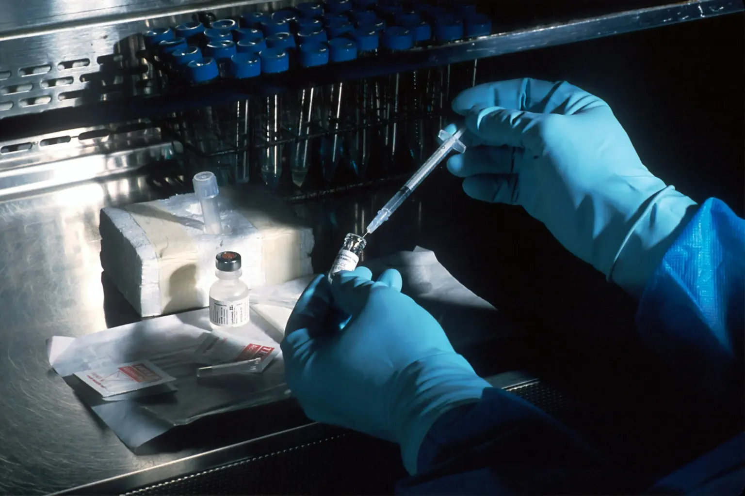 una persona que trabaja en un laboratorio inyectando un líquido en un tubo de ensayo